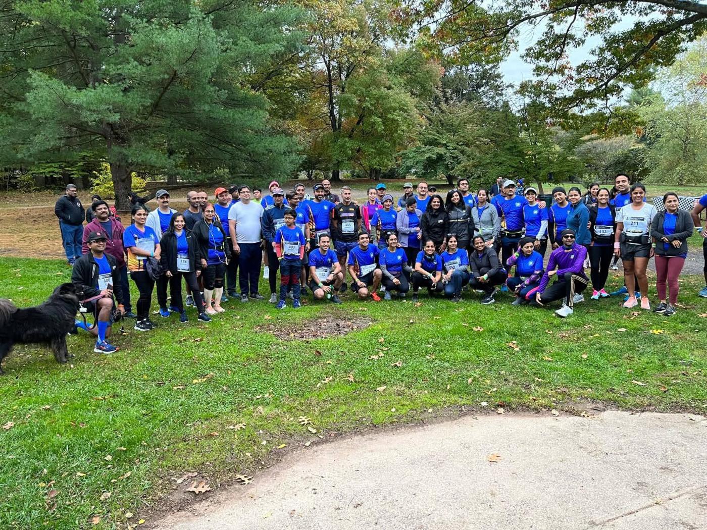 A large group in blue shirts gathered in a park