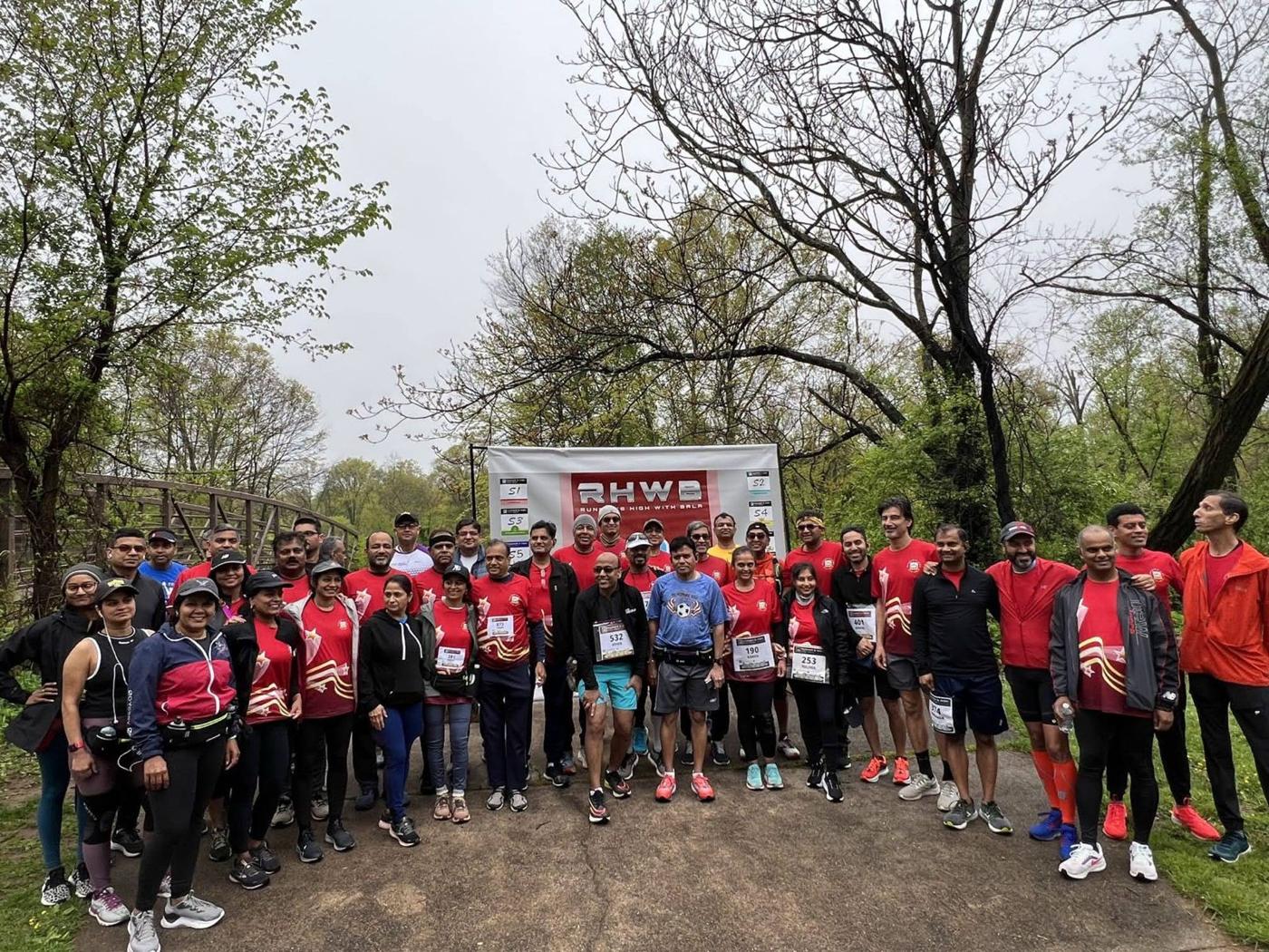 Runners in red shirts at a trailhead