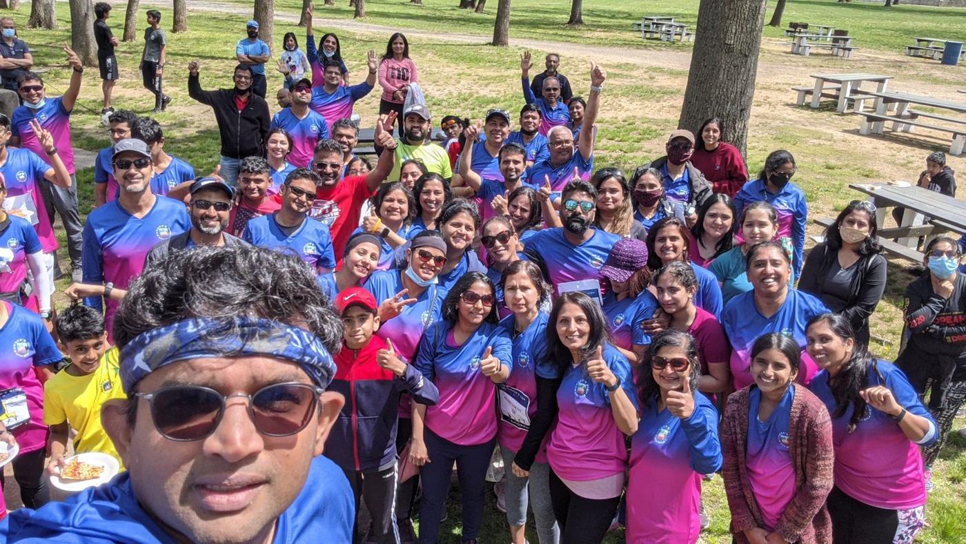 A group selfie of runners in pink and blue jerseys